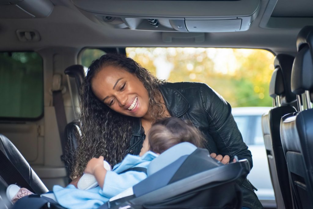 mum putting kid in car seat